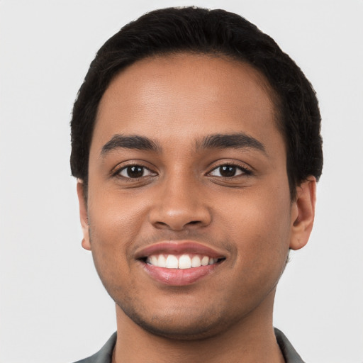 Joyful latino young-adult male with short  black hair and brown eyes