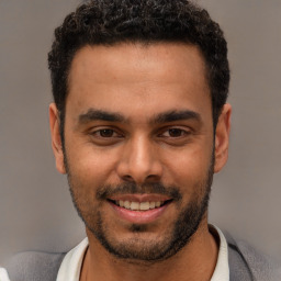 Joyful white young-adult male with short  black hair and brown eyes