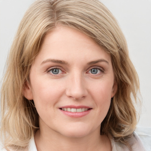 Joyful white young-adult female with medium  brown hair and blue eyes