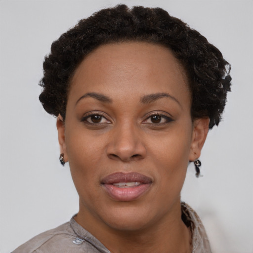 Joyful black young-adult female with short  brown hair and brown eyes