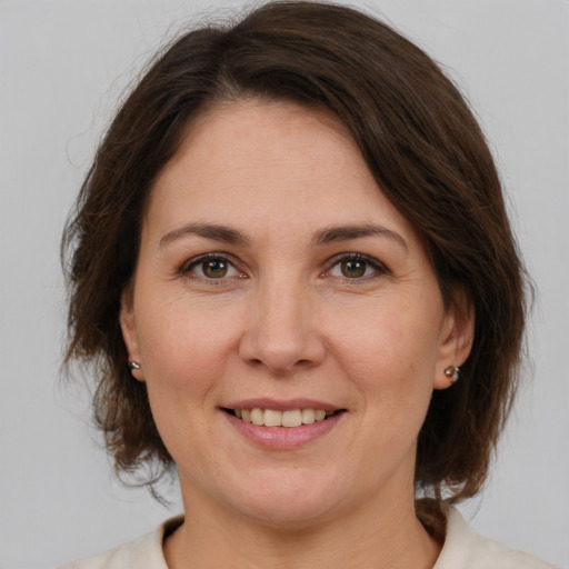 Joyful white adult female with medium  brown hair and brown eyes