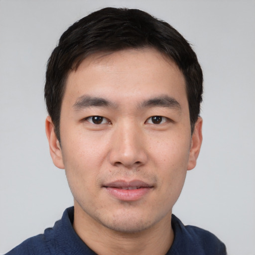Joyful asian young-adult male with short  black hair and brown eyes