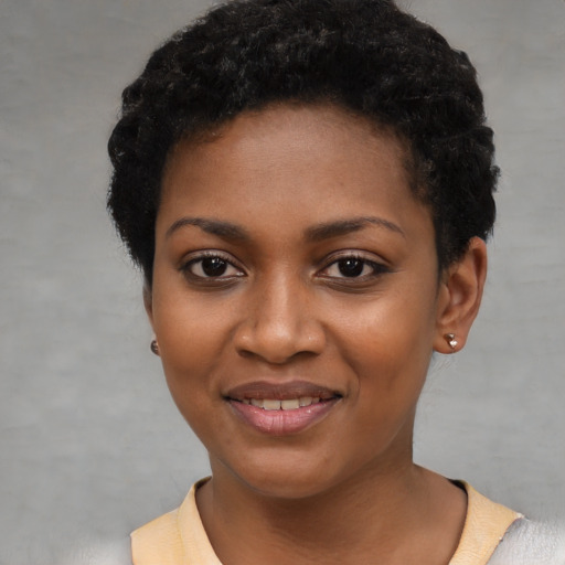 Joyful black young-adult female with short  black hair and brown eyes