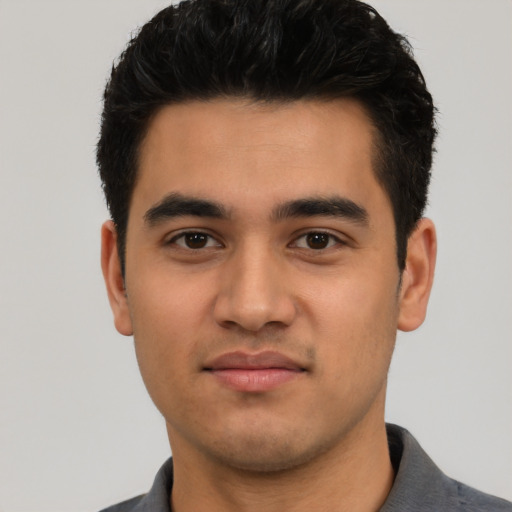 Joyful latino young-adult male with short  black hair and brown eyes