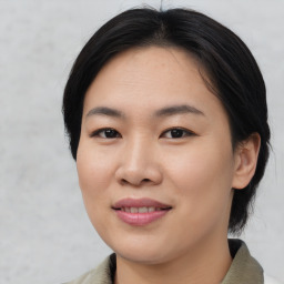 Joyful asian young-adult female with medium  black hair and brown eyes