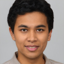 Joyful latino young-adult male with short  black hair and brown eyes
