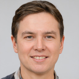 Joyful white young-adult male with short  brown hair and grey eyes