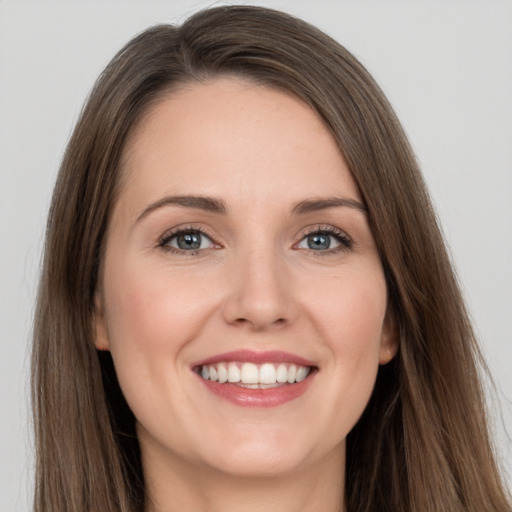 Joyful white young-adult female with long  brown hair and grey eyes