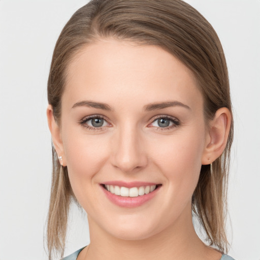 Joyful white young-adult female with medium  brown hair and grey eyes