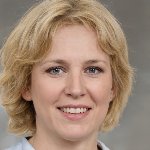 Joyful white adult female with medium  brown hair and blue eyes