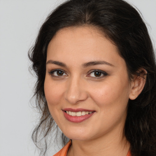 Joyful white young-adult female with long  brown hair and brown eyes