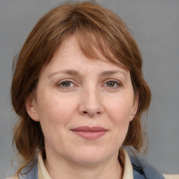 Joyful white adult female with medium  brown hair and grey eyes