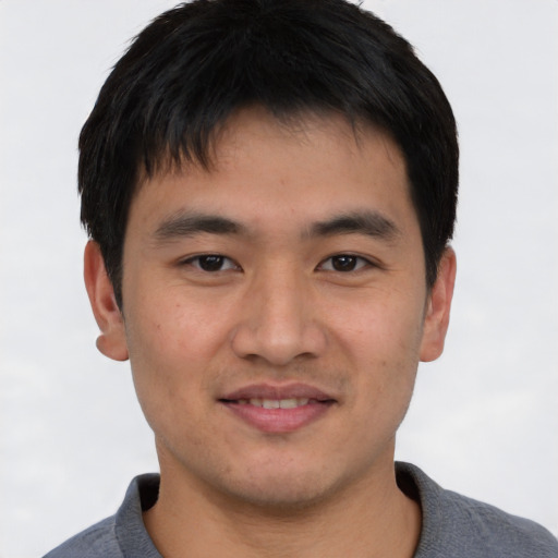 Joyful asian young-adult male with short  brown hair and brown eyes