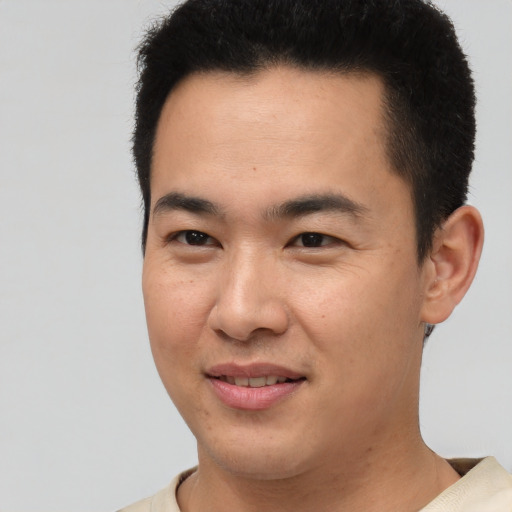 Joyful latino young-adult male with short  brown hair and brown eyes