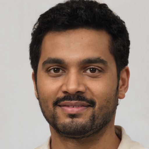 Joyful black young-adult male with short  black hair and brown eyes