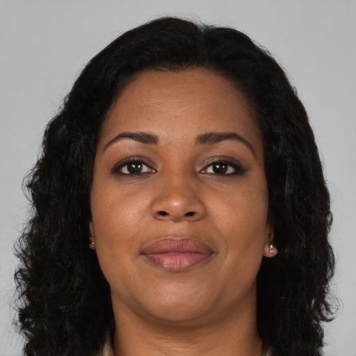 Joyful black adult female with long  brown hair and brown eyes