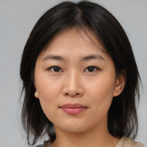 Joyful asian young-adult female with medium  brown hair and brown eyes