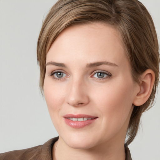 Joyful white young-adult female with medium  brown hair and grey eyes