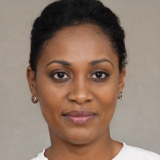 Joyful black young-adult female with short  black hair and brown eyes