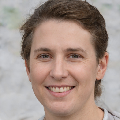 Joyful white young-adult female with short  brown hair and grey eyes