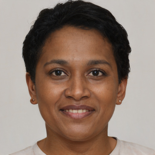 Joyful black adult female with short  black hair and brown eyes
