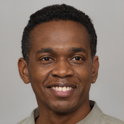 Joyful black young-adult male with short  black hair and brown eyes