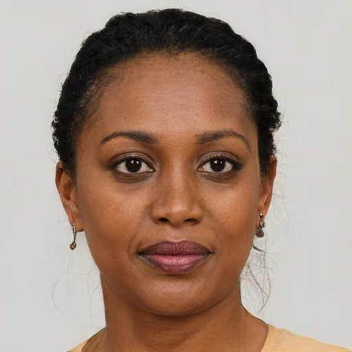 Joyful black young-adult female with short  black hair and brown eyes