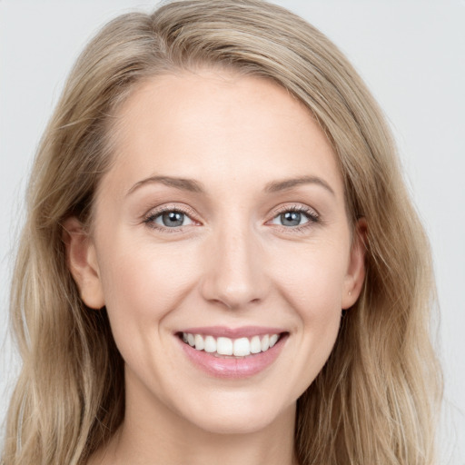 Joyful white young-adult female with long  brown hair and blue eyes