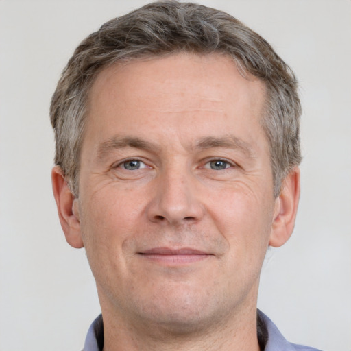 Joyful white adult male with short  brown hair and grey eyes