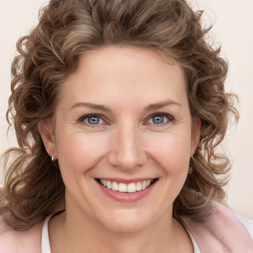 Joyful white young-adult female with medium  brown hair and blue eyes