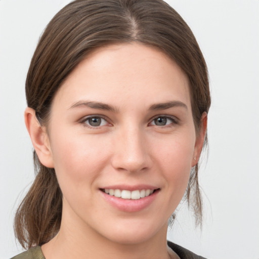 Joyful white young-adult female with medium  brown hair and grey eyes