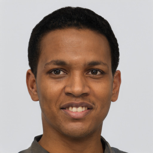 Joyful black young-adult male with short  black hair and brown eyes