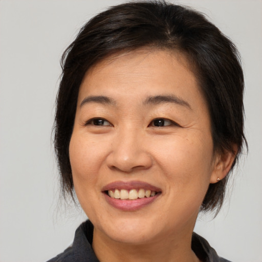 Joyful asian adult female with medium  brown hair and brown eyes