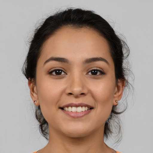 Joyful latino young-adult female with medium  brown hair and brown eyes