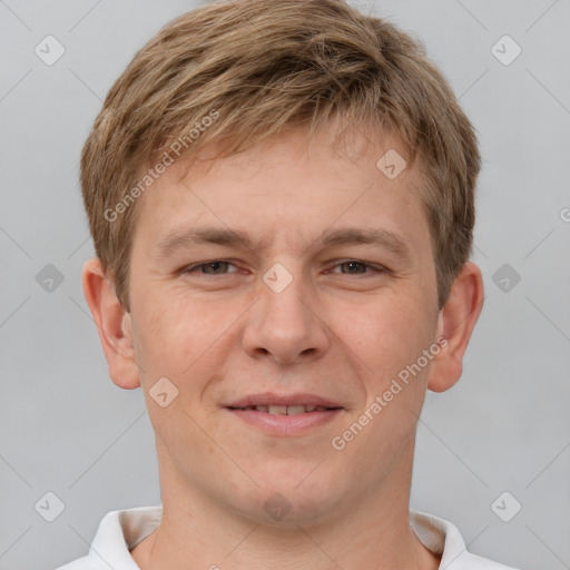 Joyful white young-adult male with short  brown hair and grey eyes