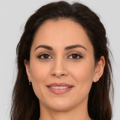 Joyful white young-adult female with long  brown hair and brown eyes