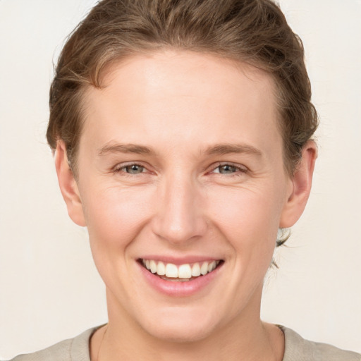 Joyful white young-adult female with short  brown hair and grey eyes