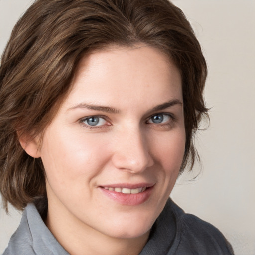 Joyful white young-adult female with medium  brown hair and grey eyes