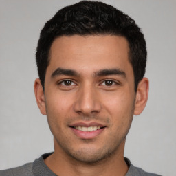 Joyful white young-adult male with short  black hair and brown eyes