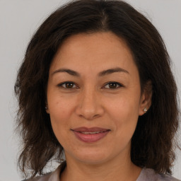 Joyful white adult female with long  brown hair and brown eyes