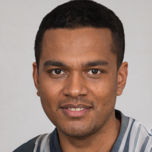 Joyful black young-adult male with short  black hair and brown eyes