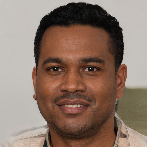 Joyful black young-adult male with short  black hair and brown eyes