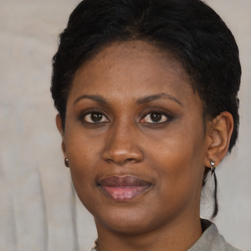 Joyful black young-adult female with short  black hair and brown eyes