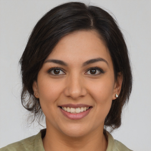 Joyful latino young-adult female with medium  brown hair and brown eyes