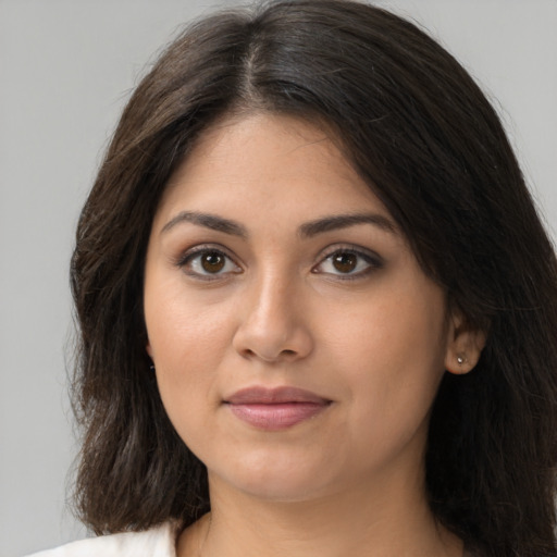 Joyful latino young-adult female with long  brown hair and brown eyes