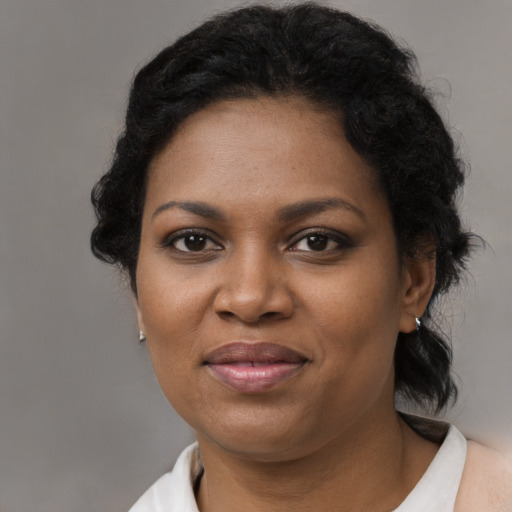 Joyful black adult female with short  brown hair and brown eyes
