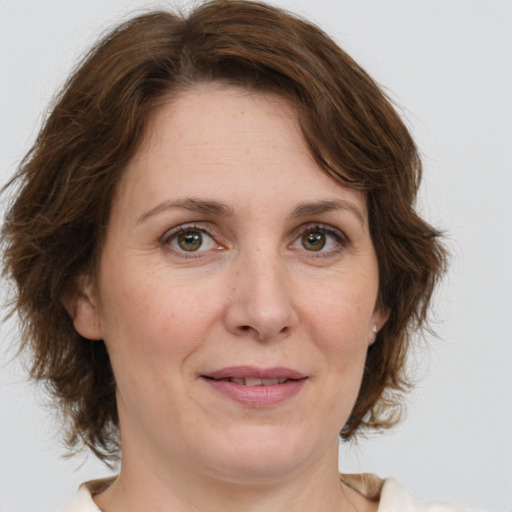 Joyful white adult female with medium  brown hair and green eyes