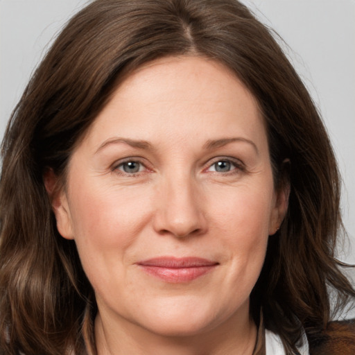 Joyful white adult female with medium  brown hair and grey eyes