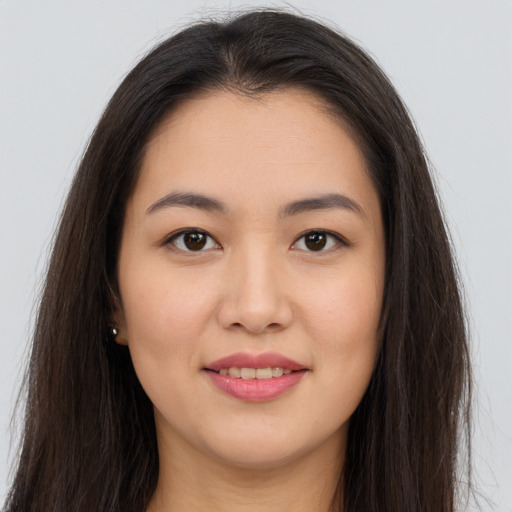 Joyful asian young-adult female with long  brown hair and brown eyes