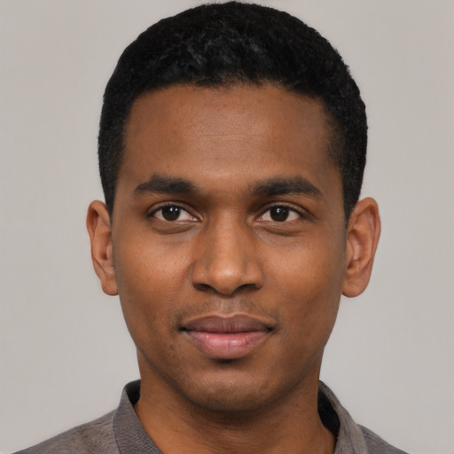 Joyful black young-adult male with short  black hair and brown eyes